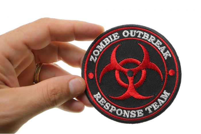 Zombie OutBreak Response Team Red Funny Iron on Patch shown on hand for size comparison