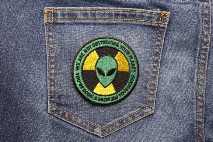 Alien Warning Patch We Are Not Destroying Your Planet You're Doing A Great Job shown on jeans