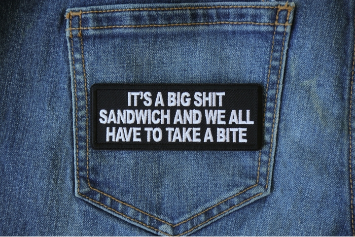 It's a Big Shit Sandwich and We all have to take a Bite Funny Iron on Patch shown on jeans