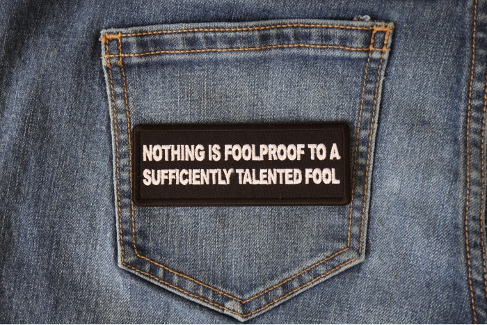 Nothing is Foolproof to a Sufficiently Talented Fool Funny Iron on Patch shown on jeans