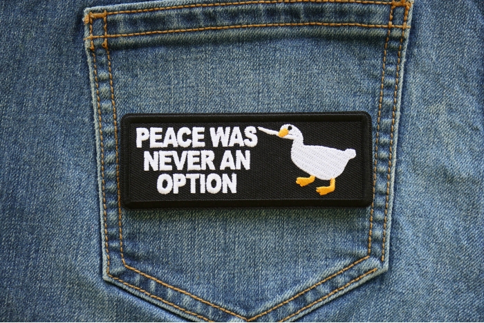 Peace Was Never an Option Duck with Knife Iron on Patch shown on jeans