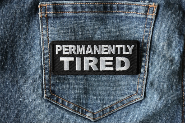 Permanently Tired Patch shown on jeans