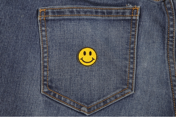 Smiley Patch 1 Inch Yellow shown on jeans