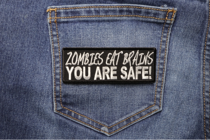 Zombies Eat Brains You Are Safe Funny Iron on Patch shown on jeans