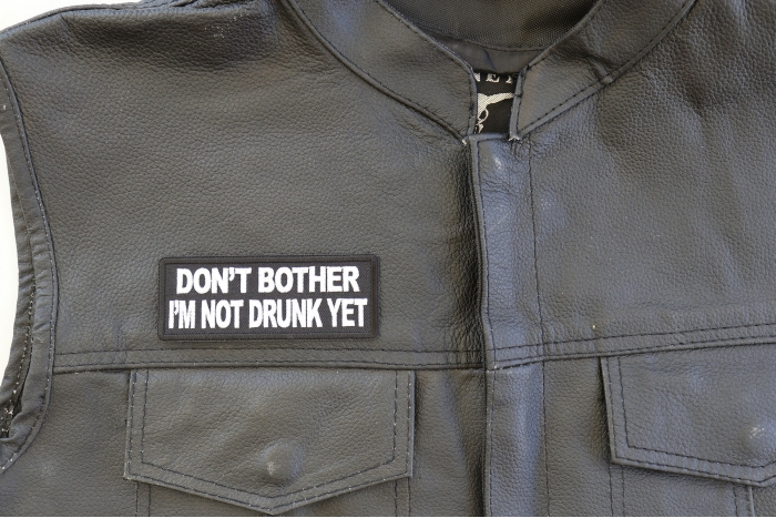 Don't Bother I'm Not Drunk Yet Patch - 4x1.5 inch. Embroidered Iron on Patch shown on leather vest
