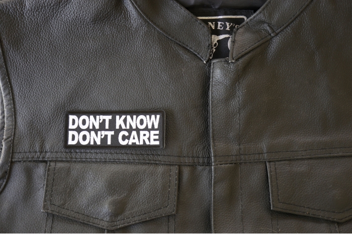 Don't Know Don't Care Patch - 4x1.5 inch. Embroidered Iron on Patch shown on leather vest