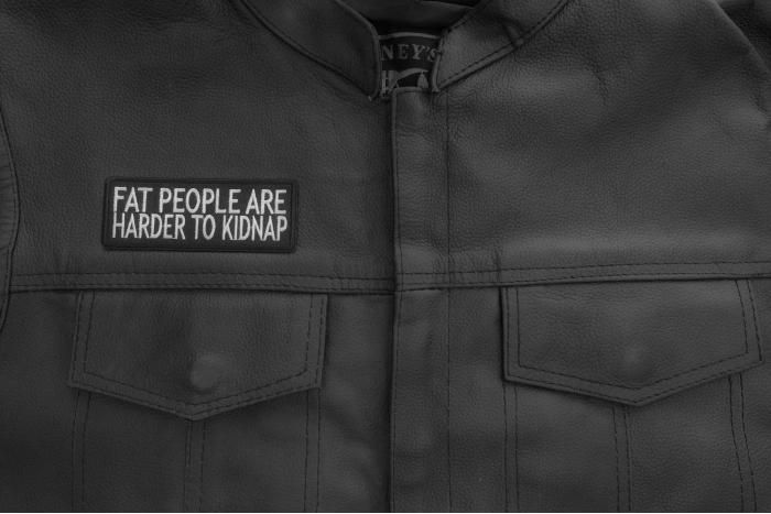 Fat People Are Harder To Kidnap Patch - 4x1.75 inch. Embroidered Iron on Patch shown on leather vest