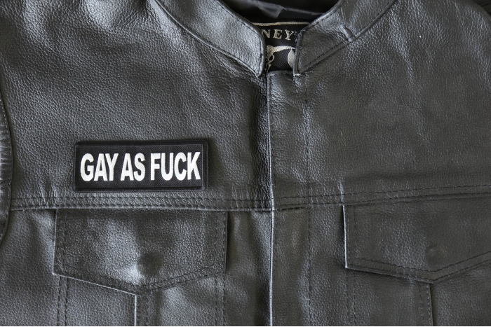 Gay as Fuck Patch - 4x1.5 inch - Embroidered Iron on Patch shown on leather vest