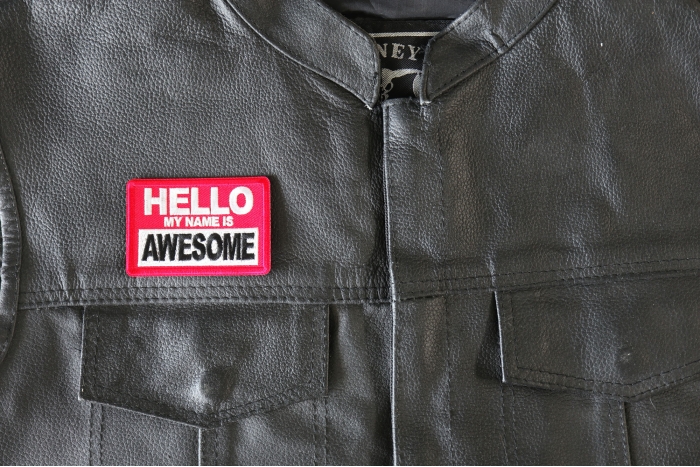 Hello My Name is Awesome Patch - 3x2 inch - Embroidered Iron on Patch shown on leather vest