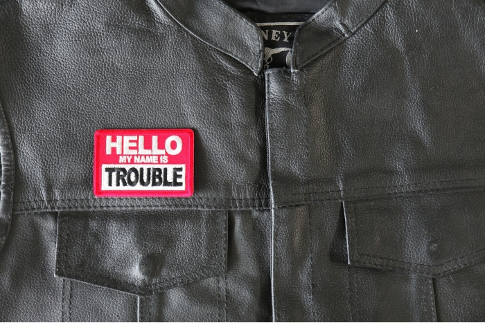 Hello My Name is Trouble Patch - 3x2 inch - Embroidered Iron on Patch shown on leather vest