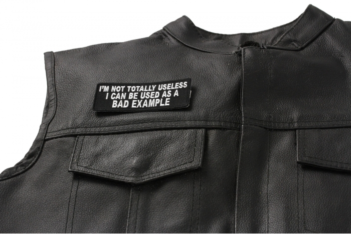 I'm Not Totally Useless I Can Be Used As A Bad Example Patch - 4x1.5 inch. Embroidered Iron on Patch shown on leather vest