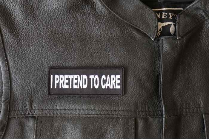 I Pretend to Care Patch - 4x1.5 inch - Embroidered Iron on Patch shown on leather vest