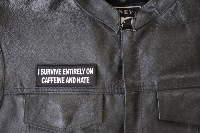 I survive entirely on Caffeine and Hate Patch - 4x1.5 inch - Embroidered Iron on Patch shown on leather vest