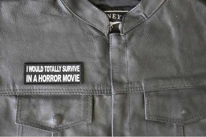 I Would Totally Survive in a Horror Movie Patch - 4x1.5 inch - Embroidered Iron on Patch shown on leather vest