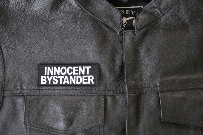 Innocent Bystander Patch - 4x1.5 inch - Embroidered Iron on Patch shown on leather vest