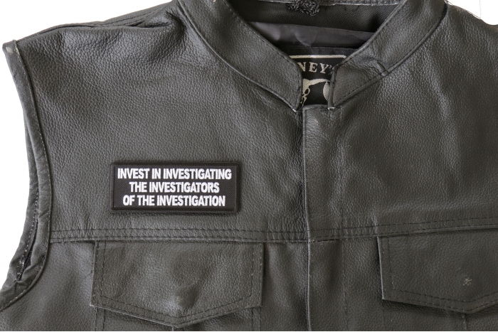 Invest in Investigating The Investigators of The Investigation Patch - 4x1.5 inch. Embroidered Iron on Patch shown on leather vest