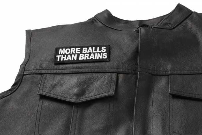 More Balls Than Brains Patch - 4x1.5 inch. Embroidered Iron on Patch shown on leather vest
