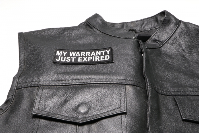 My Warranty Just Expired Patch - 4x1.5 inch. Embroidered Iron on Patch shown on leather vest