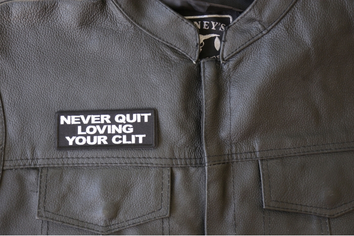 Never Quit Loving Your Clit Patch - 4x1.5 inch - Embroidered Iron on Patch shown on leather vest