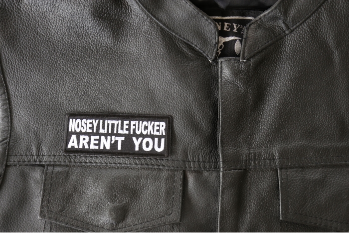 Nosey Little Fucker Aren't You Patch - 4x1.5 inch - Embroidered Iron on Patch shown on leather vest