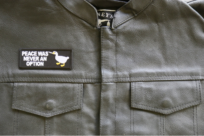 Peace Was Never an Option Duck with Knife Iron on Patch shown on leather vest