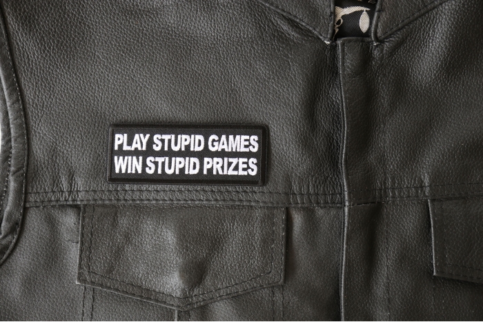 Play Stupid Games Win Stupid Prices Patch - 4x1.5 inch - Embroidered Iron on Patch shown on leather vest