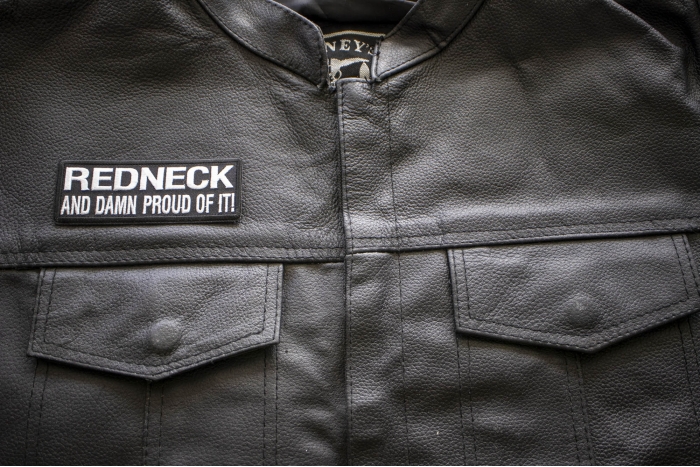 Redneck and Damn Proud Of It! Patch - 4x1.75 inch. Embroidered Iron on Patch shown on leather vest