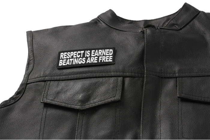 Respect Is Earned Beatings Are Free Funny Patch - 4x1.5 inch. Embroidered Iron on Patch shown on leather vest