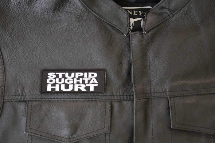 Stupid Oughta Hurt Patch - 4x1.5 inch - Embroidered Iron on Patch shown on leather vest