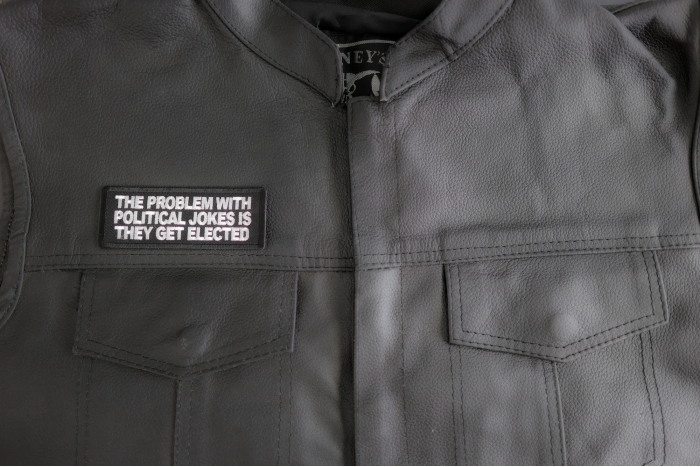 The Problem With Political Jokes Is They Get Elected Patch shown on leather vest