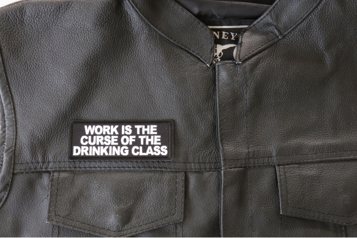 Work is The Curse of The Drinking Class Patch - 4x1.5 inch. Embroidered Iron on Patch shown on leather vest