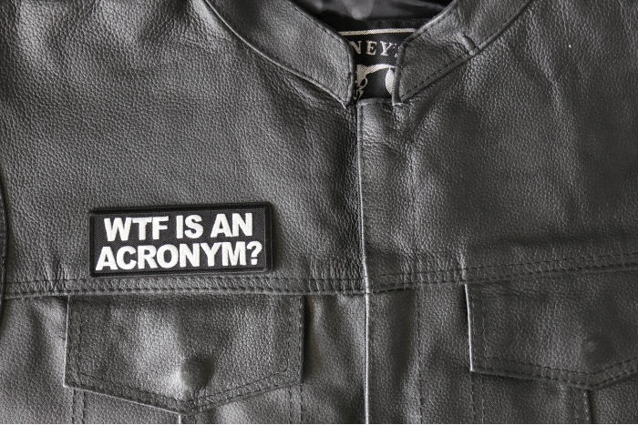 WTF is an Acronym Patch - 4x1.5 inch - Embroidered Iron on Patch shown on leather vest