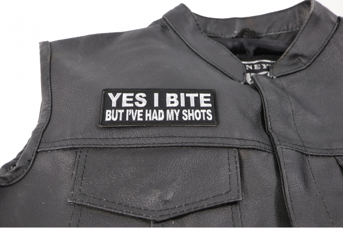Yes I Bite But I've Had My Shots Patch - by Ivamis Trading - 4x1.5 inch - Embroidered Iron on Patch shown on leather vest
