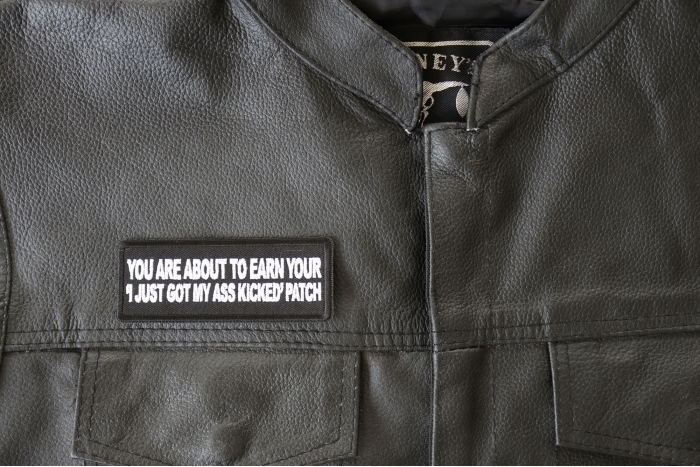 You are About to earn your I just got my Ass Kicked Patch - 4x1.5 inch - Embroidered Iron on Patch shown on leather vest