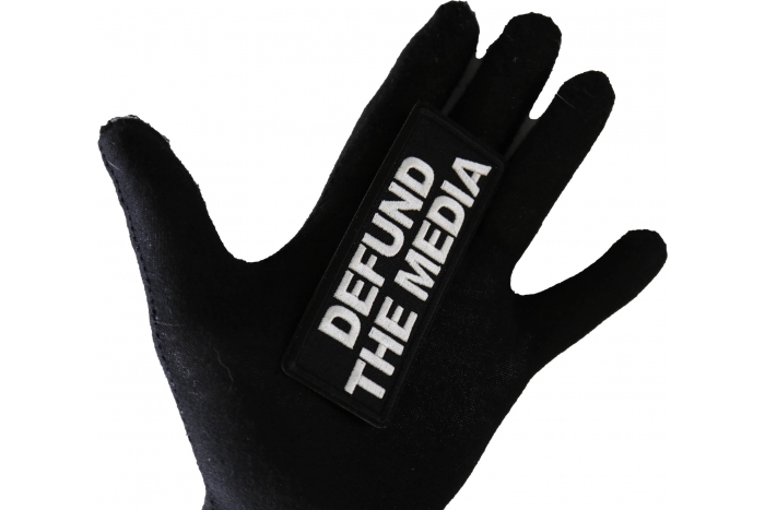 Defund the Media Patch shown on hand for size comparison
