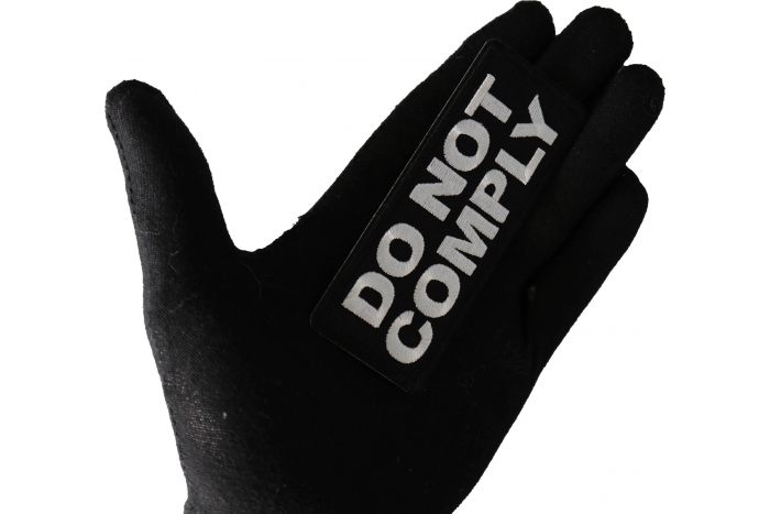 Do not Comply Patch shown on hand for size comparison