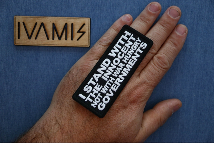 I Stand with the innocent Not with a war hungry Governments Patch shown on hand for size comparison