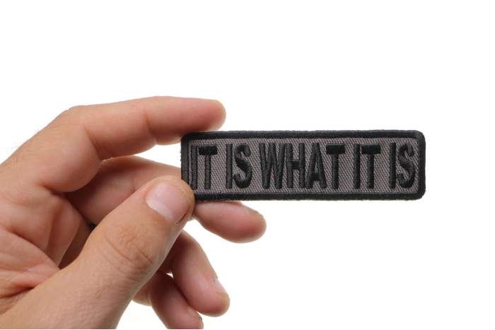 It Is What It Is Iron on Morale Patch In Gray shown on hand for size comparison