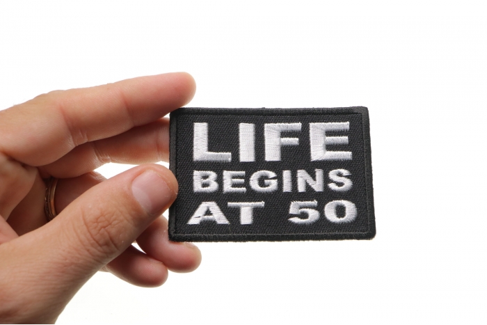 Life Begins at 50 Iron on Patch shown on hand for size comparison