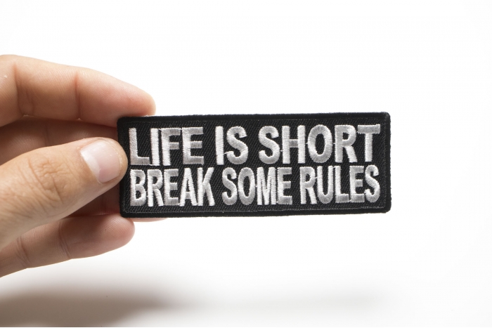 Life Is Short Break Some Rules Iron on Morale Patch shown on hand for size comparison