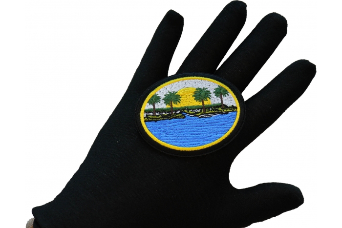 Sea and Palms Sunset Iron on Patch shown on hand for size comparison