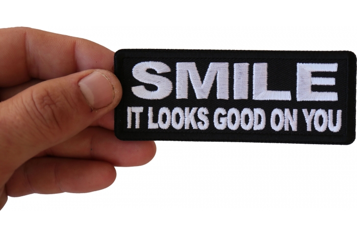Smile It Looks Good on You Iron on Morale Patch shown on hand for size comparison