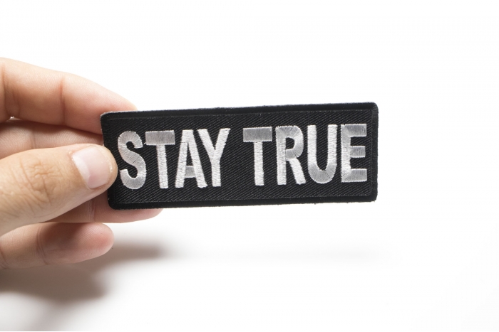 Stay True Iron on Morale Patch shown on hand for size comparison