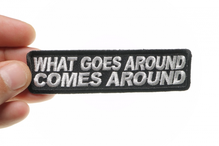 What Goes Around Comes Around Iron on Saying Iron on Patch shown on hand for size comparison