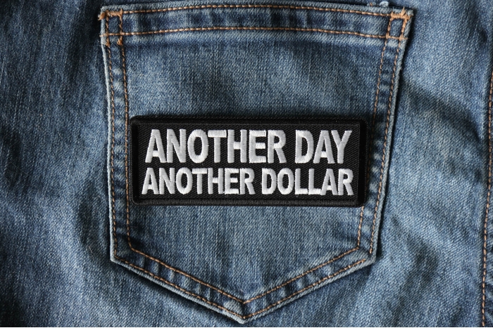 Another Day Another Dollar Patch shown on jeans