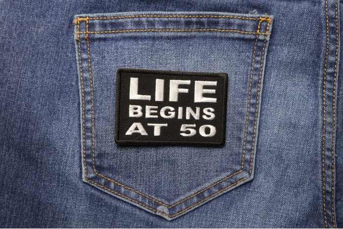 Life Begins at 50 Patch - Embroidered - Sew or Iron on to Jackets shown on jeans