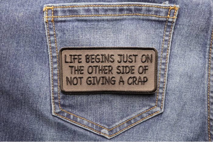 Life Begins Just On The Other Side Of Not Giving A Crap Iron on Morale Patch shown on jeans