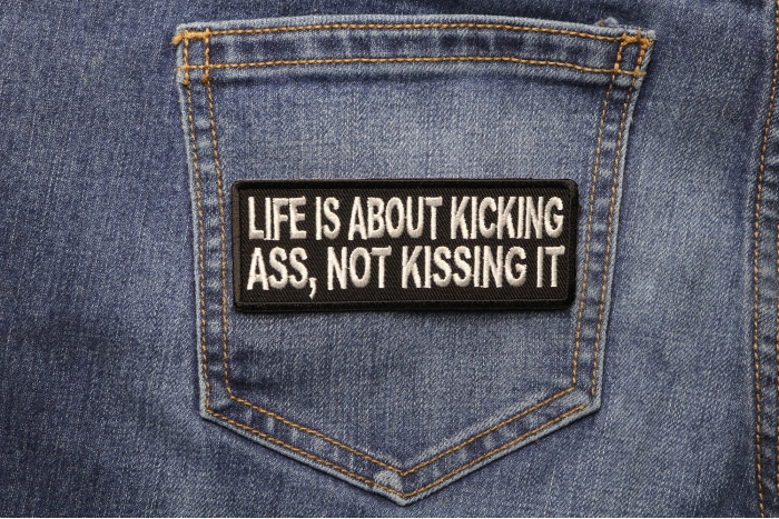 Life Is About Kicking Ass Not Kissing It Patch shown on jeans