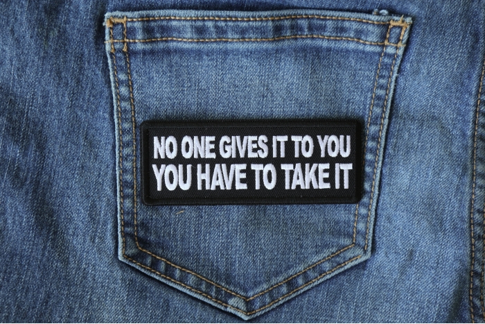 No One Gives it to You You have to Take It Patch shown on jeans
