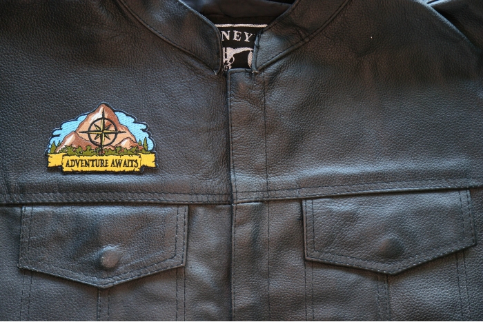 Adventure Awaits Hiker Patch shown on leather vest